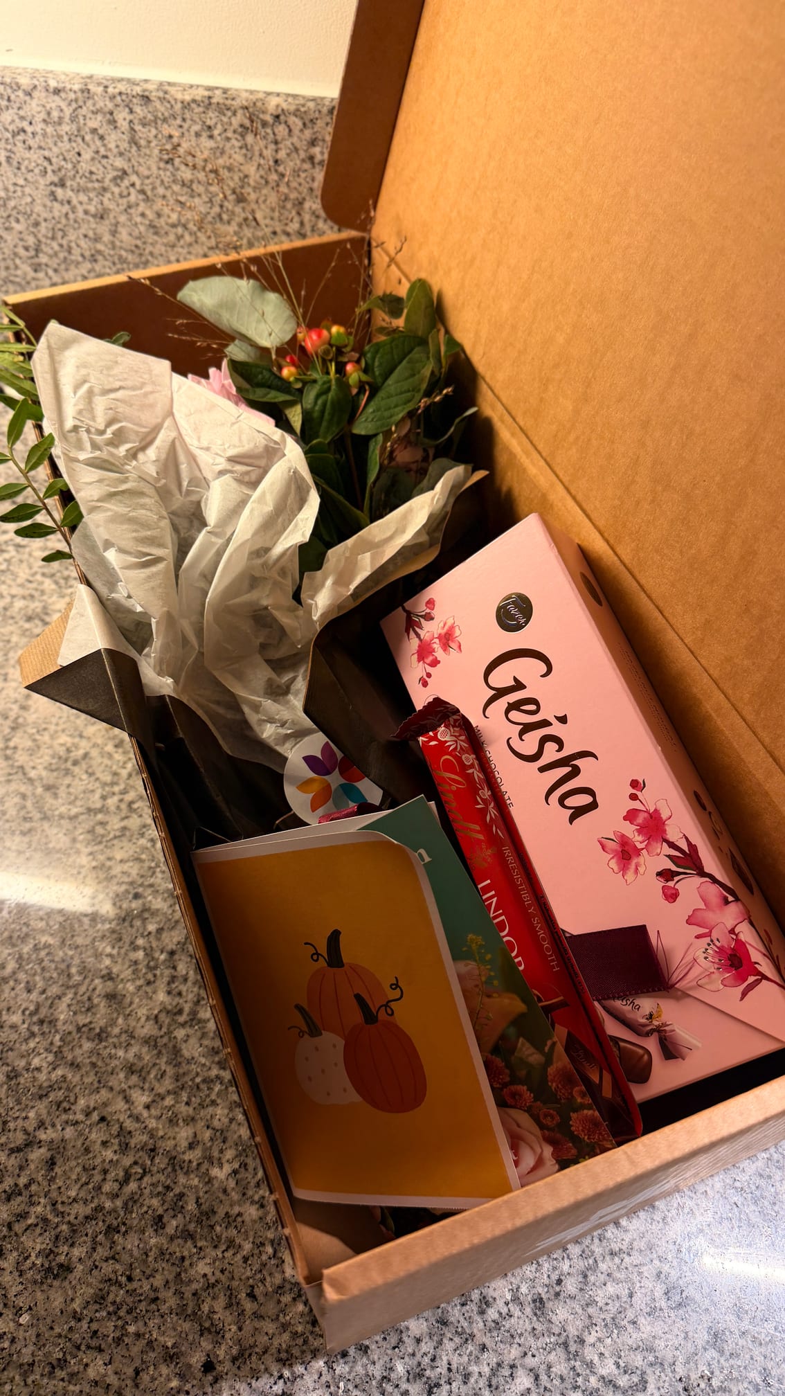 Euroflorists låda öppnad med bukett, chokladask och kort